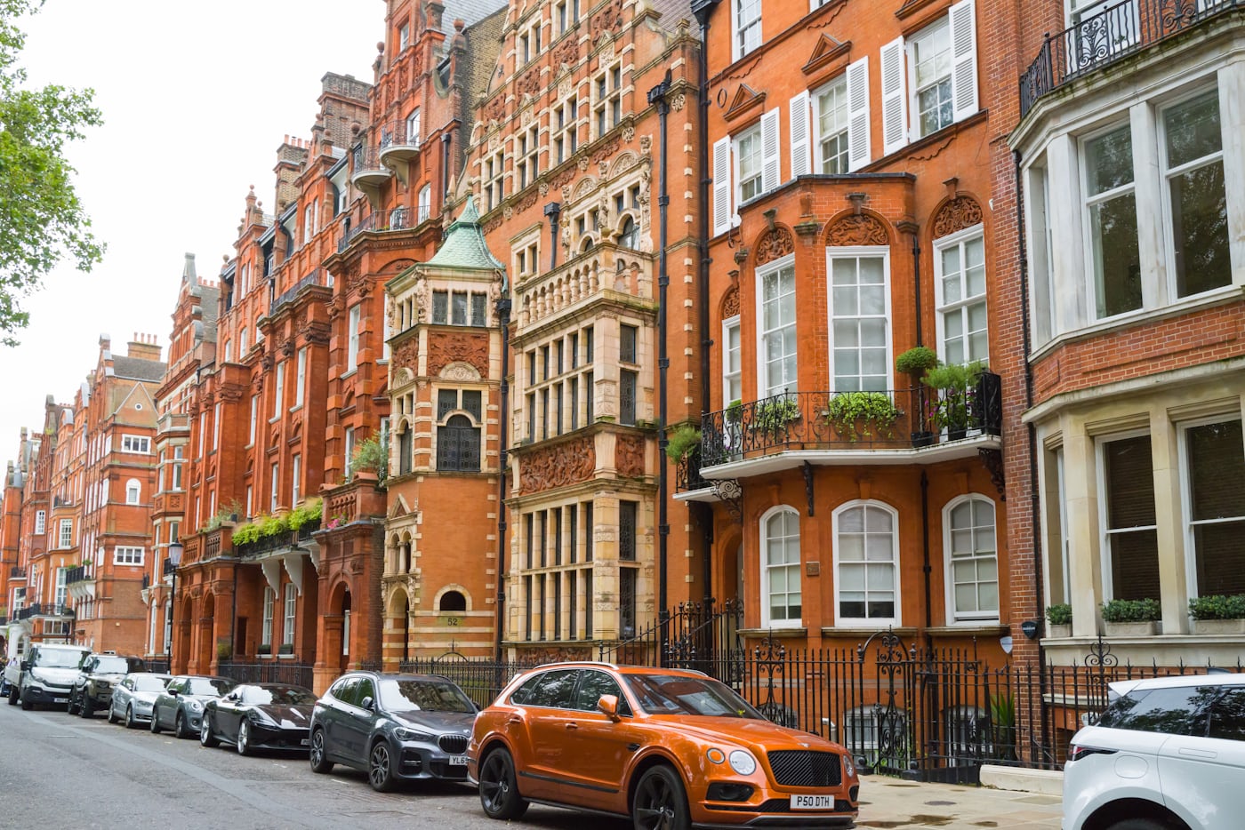 A terrace of tall brick townhouses on a city street